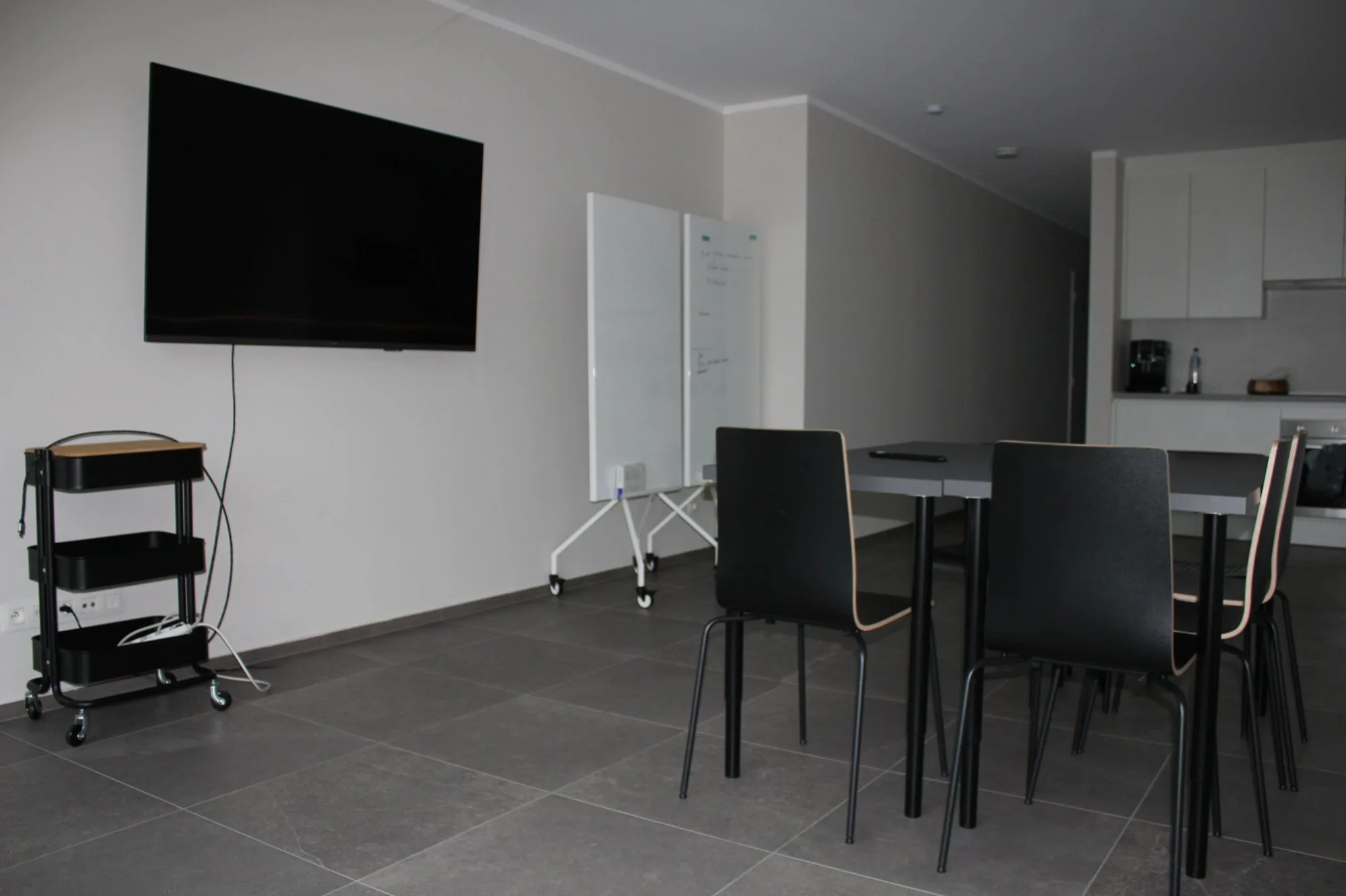 De vergader- en workshopruimte met grote tafel, scherm en whiteboards